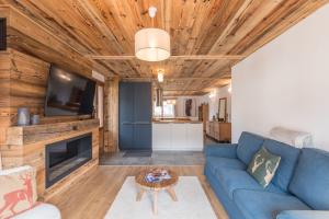 a living room with a blue couch and a tv at Magnificent chalet with view in Praz-sur-Arly - Welkeys in Praz-sur-Arly