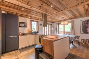 a kitchen with wooden ceilings and a table in a room at Magnificent chalet with view in Praz-sur-Arly - Welkeys in Praz-sur-Arly