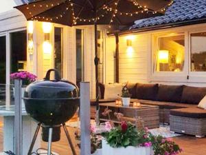 een patio met een barbecue en een bank bij Holiday home Ronneby XIV in Ronneby