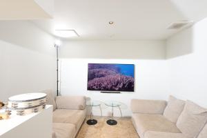 Beach Terrace Kushimoto - Vacation STAY 37415v في Wabuka: غرفة معيشة مع أريكة ولوحة على الحائط