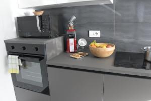 una cucina con forno a microonde e cesto di frutta di Giada a Casalgrande