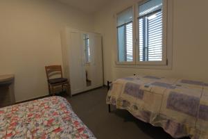 ein Schlafzimmer mit einem Bett, einem Fenster und einem Stuhl in der Unterkunft Giada in Casalgrande