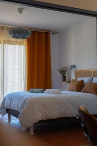 ein Schlafzimmer mit einem großen Bett und einem Fenster in der Unterkunft Appartement T3 bas de Villa in Vero