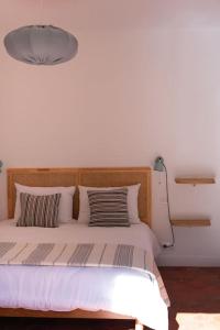 a bed with a wooden headboard in a bedroom at Appartement T3 bas de Villa in Vero