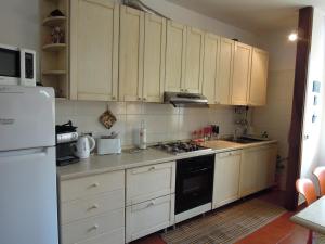 uma cozinha com armários brancos e um forno de fogão preto em Villa C&C em Lierna