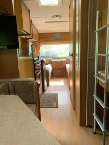 a small room with a kitchen and a living room at Family time in the Welsh hills! in Llanfyllin
