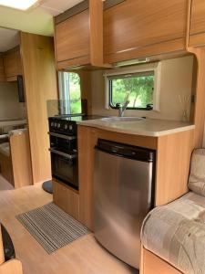 a kitchen with a sink and a stove at Family time in the Welsh hills! in Llanfyllin