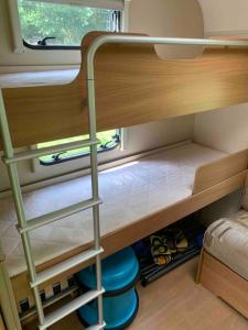 a small room with a bunk bed with shoes in it at Family time in the Welsh hills! in Llanfyllin