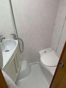 a white bathroom with a sink and a toilet at Family time in the Welsh hills! in Llanfyllin