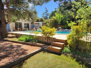 a backyard with a swimming pool and a house at Domaine Les Gendalis in Saint-Saturnin-les-Avignon