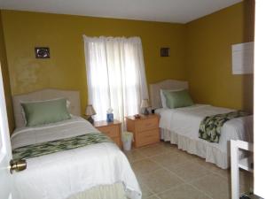 een slaapkamer met 2 bedden en een raam bij A Family Place For You in Port Saint Lucie