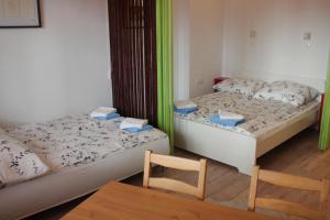 2 camas en una habitación con mesa y 2 sillas en Casa Mate', en Budapest