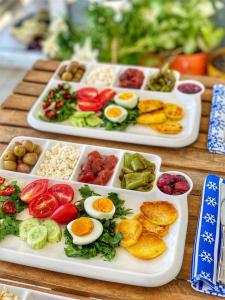 deux assiettes de denrées alimentaires sur une table avec des œufs et des légumes dans l'établissement Dalaman Airport AliBaba House, à Dalaman
