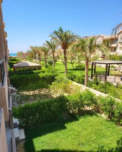 uma vista para um parque com palmeiras e um gazebo em Tavira Resort em Ras Sedr