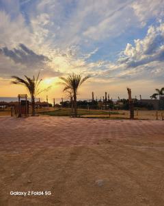 um pôr-do-sol com palmeiras num parque em Tavira Resort em Ras Sedr