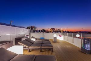 a rooftop deck with couches and a view of the city at Ferienwohnung in Son Baulo mit Grill in Can Picafort