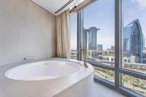 a bathroom with a tub and a large window at Burj Khalifa, Armani hotel 1 bedroom apartment in Dubai