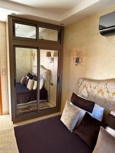 1 dormitorio con espejo, 1 cama y 1 sofá en Riad Jad - Sweet Duplex Appartement en Marrakech