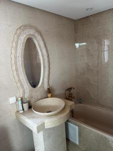 W łazience znajduje się umywalka, lustro i wanna. w obiekcie Riad Jad - Sweet Duplex Appartement w Marakeszu