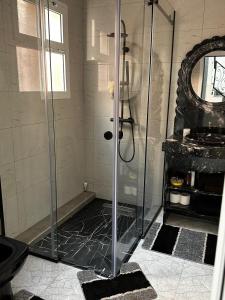 een douche met een glazen deur in een badkamer bij Riad Jad - Sweet Duplex Appartement in Marrakesh