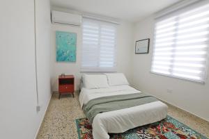 1 Schlafzimmer mit 2 Betten, einem Tisch und Fenstern in der Unterkunft Casa Lula Beach Retreat - Dog friendly, Fenced backyard in Arecibo