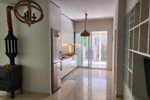 a kitchen with white cabinets and a refrigerator in a room at Alba's House Lura1 Residence in Draç