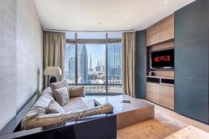 a living room with a couch and a tv at Burj Khalifa, Armani hotel 1 bedroom apartment in Dubai