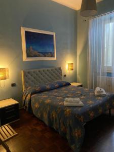 a bedroom with a bed with a blue comforter at Appartamento Forte Malatesta in Ascoli Piceno