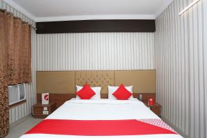 GharaundaにあるOYO Hotel K-townのベッドルーム1室(大型ベッド1台、赤い枕付)