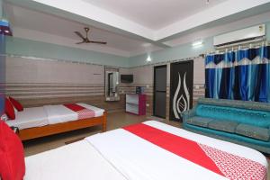 une chambre d'hôtel avec deux lits et un canapé dans l'établissement OYO Prantika Banquet, à Digha