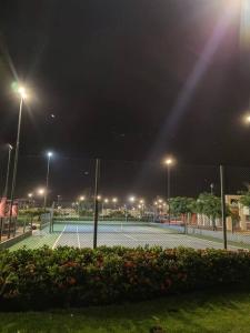 a tennis court at night with lights on at Cozy family home in private condo in Santa Cruz de la Sierra