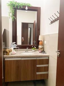 a bathroom with a sink and a large mirror at Cozy family home in private condo in Santa Cruz de la Sierra