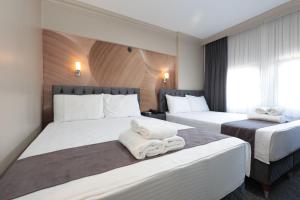 a hotel room with two beds with towels on them at BURSA LOYAL CiTY HOTEL & SPA in Bursa