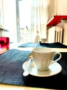 una taza en un plato en una mesa con una cuchara en Casa Langhetto, en Grinzane Cavour