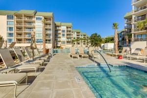 a swimming pool with chaise lounge chairs and a resort at Palmetto Dunes Villa with Lagoon and Fountain Views in Hilton Head Island