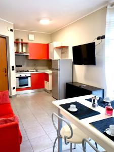 una cocina con armarios rojos y una mesa con sillas. en Casa Langhetto, en Grinzane Cavour