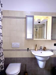 a bathroom with a sink and a toilet and a mirror at Casa Langhetto in Grinzane Cavour