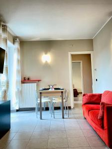 a living room with a table and a red couch at Casa Langhetto in Grinzane Cavour