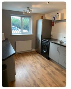 a kitchen with a refrigerator and a dishwasher at The Little House, Oswestry in Chirk