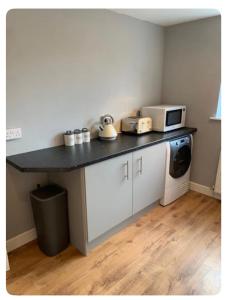 a kitchen with a counter top with a microwave at The Little House, Oswestry in Chirk
