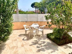 um pátio com uma mesa, cadeiras e uma árvore em Palau del Vidre - Villa à 8 min d’Argeles sur Mer em Palau-del-Vidre