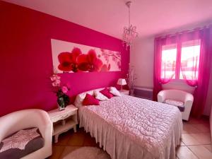 um quarto com paredes cor-de-rosa e uma cama com almofadas cor-de-rosa em Palau del Vidre - Villa à 8 min d’Argeles sur Mer em Palau-del-Vidre