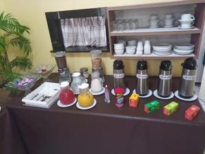 a table with plates and condiments on top at Hotel American in Ariquemes