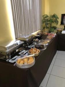ein Buffet mit Schalen mit Speisen auf der Theke in der Unterkunft Hotel American in Ariquemes