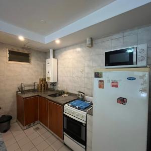 een keuken met een witte koelkast en een magnetron bij Jardines De Oro in Cordoba
