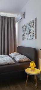 a bedroom with a bed and a table with a lamp at Urban Sunset Apartment in Sibiu