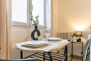 een houten tafel met een bord en een wijnglas bij Appartement 2 personnes Neuf RDC in Gennevilliers