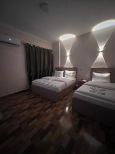 开罗Cairo Casa Hotel的酒店客房,设有两张床,墙上有灯