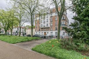 een park voor een groot gebouw bij Appartement 2 personnes Neuf RDC in Gennevilliers