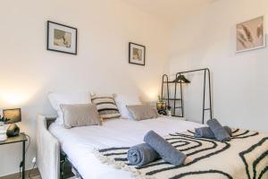 een slaapkamer met een wit bed met blauwe kussens erop bij Appartement 2 personnes Neuf RDC in Gennevilliers